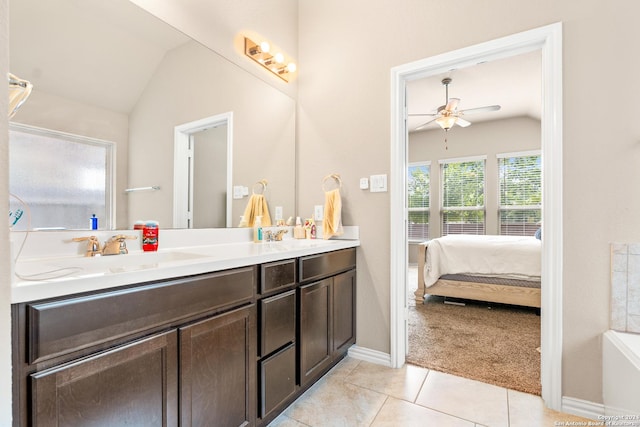 bathroom with ceiling fan, tile patterned flooring, vanity, and vaulted ceiling