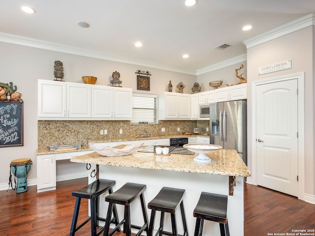 kitchen with a center island, light stone counters, and appliances with stainless steel finishes