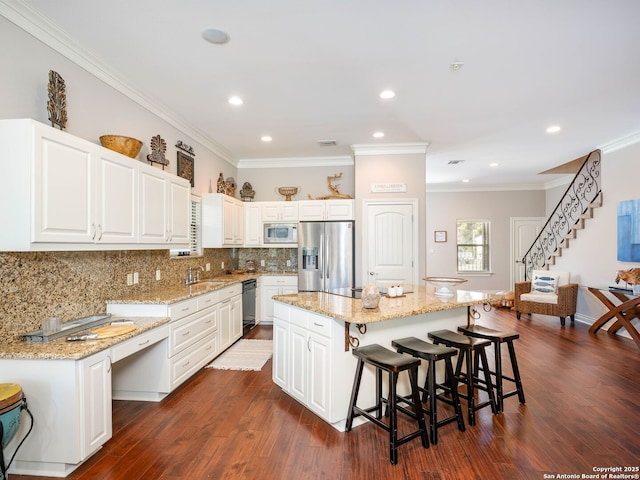 kitchen featuring built in microwave, a center island, black dishwasher, stainless steel fridge, and white cabinets