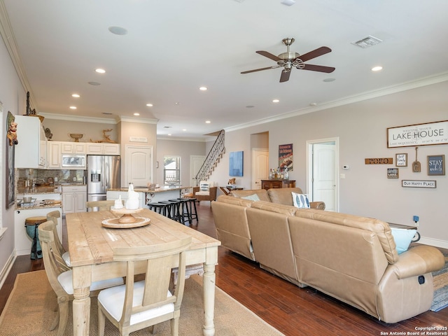 dining space with ornamental molding, ceiling fan, and dark wood-type flooring