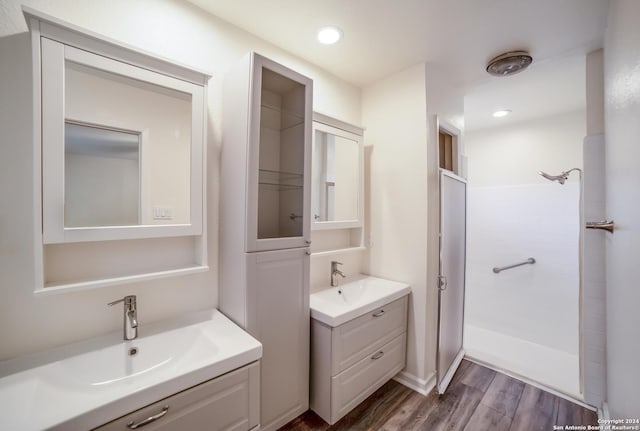 bathroom with a shower, hardwood / wood-style floors, and vanity