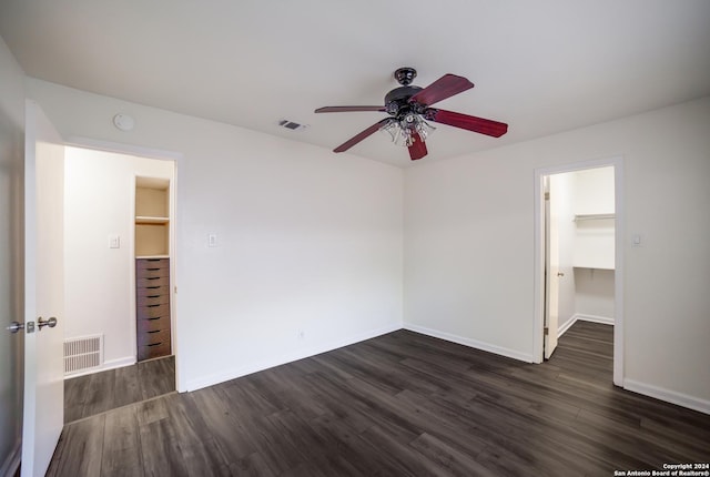 unfurnished bedroom with a spacious closet, a closet, and ceiling fan