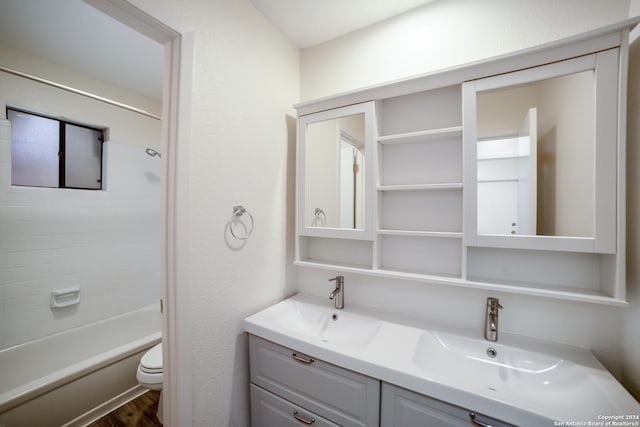 full bathroom with vanity, toilet, wood-type flooring, and tiled shower / bath