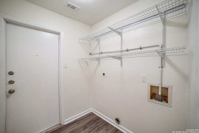 clothes washing area with dark hardwood / wood-style flooring, washer hookup, and hookup for an electric dryer