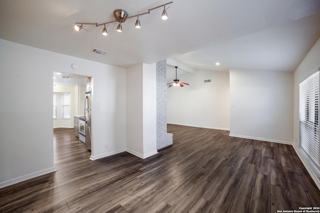 empty room featuring lofted ceiling with beams, dark hardwood / wood-style floors, plenty of natural light, and ceiling fan