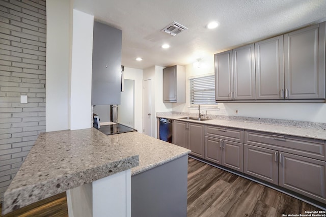 kitchen with sink, gray cabinets, a textured ceiling, dishwashing machine, and light stone counters