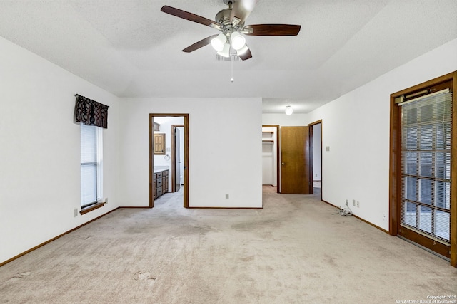 unfurnished room featuring light carpet, a wealth of natural light, a textured ceiling, and ceiling fan