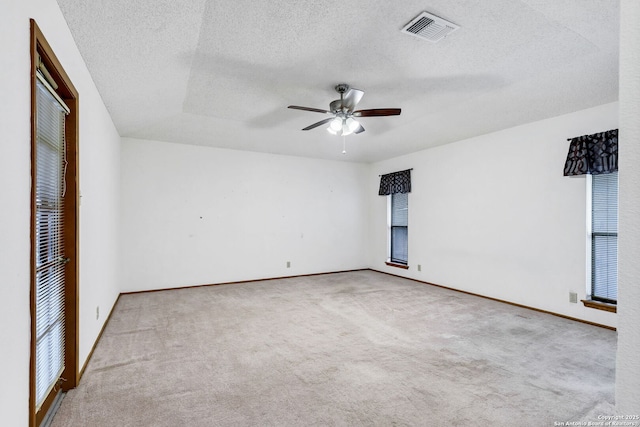 carpeted spare room with ceiling fan and a textured ceiling