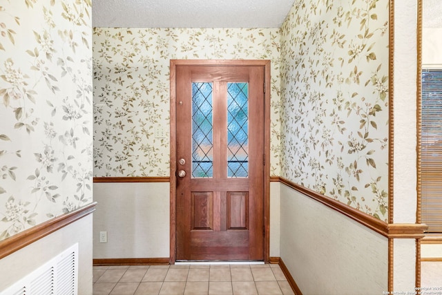 tiled entryway featuring a textured ceiling