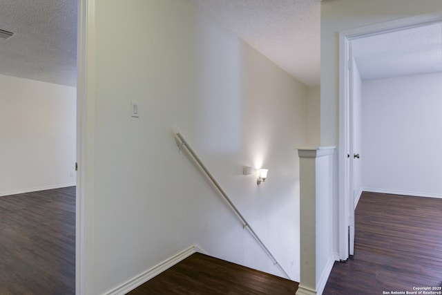 stairway featuring hardwood / wood-style flooring and a textured ceiling