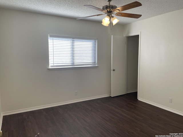 spare room featuring ceiling fan, dark hardwood / wood-style floors, and a textured ceiling