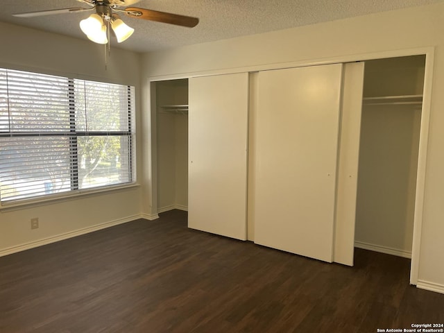 unfurnished bedroom with a textured ceiling, dark hardwood / wood-style floors, and ceiling fan