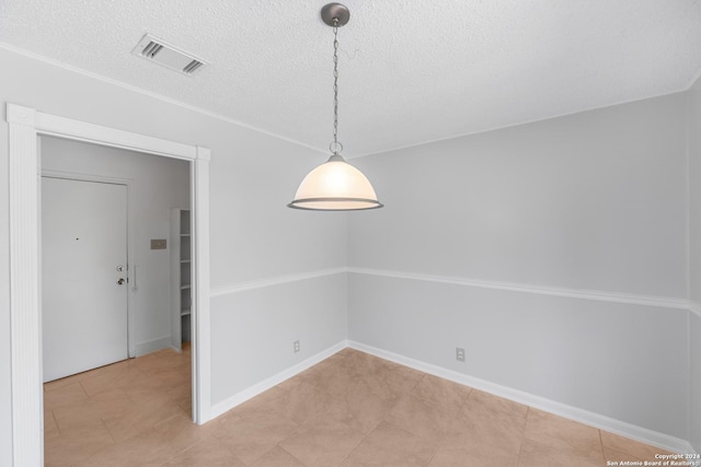 unfurnished dining area with light tile patterned floors and a textured ceiling