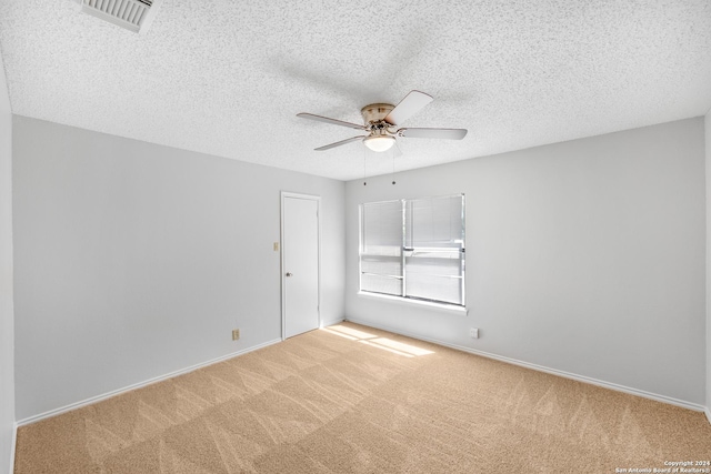 spare room with light carpet, a textured ceiling, and ceiling fan