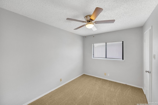 spare room with a textured ceiling, ceiling fan, and light carpet