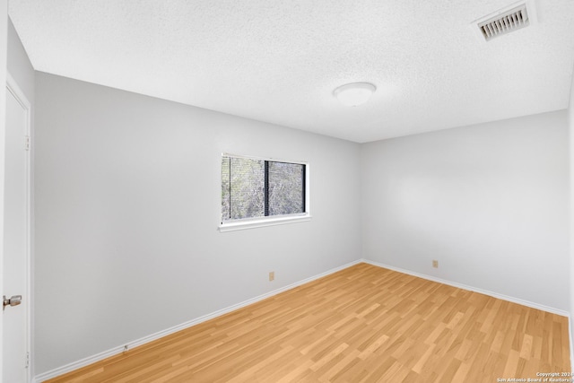 empty room featuring a textured ceiling and light wood-type flooring