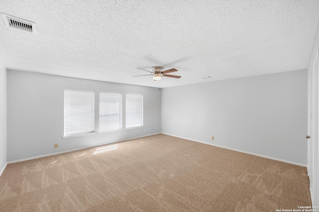 carpeted spare room with ceiling fan and a textured ceiling