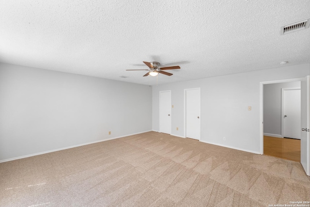 carpeted spare room with ceiling fan and a textured ceiling