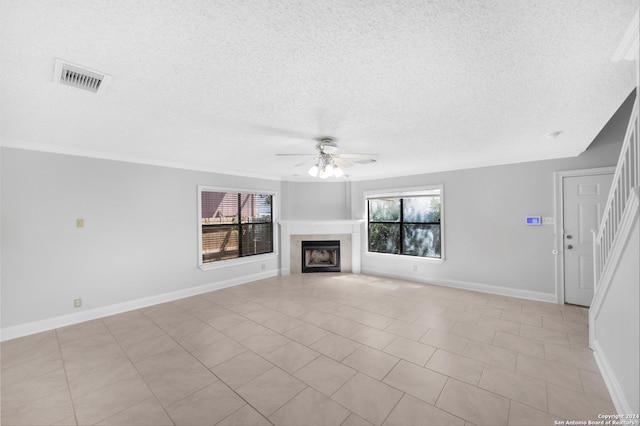 unfurnished living room with ceiling fan and a textured ceiling