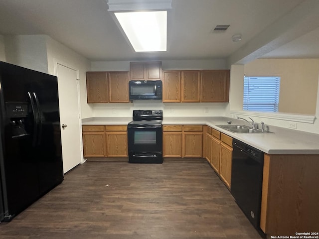 kitchen with black appliances, dark hardwood / wood-style flooring, and sink