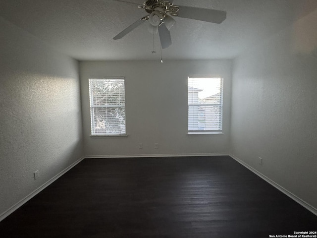 spare room featuring ceiling fan and dark hardwood / wood-style floors