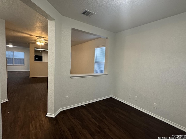 unfurnished room featuring ceiling fan, dark hardwood / wood-style flooring, and a textured ceiling