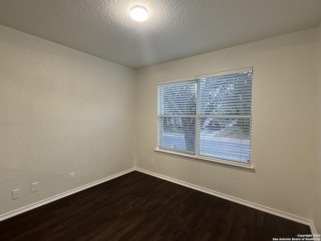 unfurnished room featuring wood-type flooring and a textured ceiling