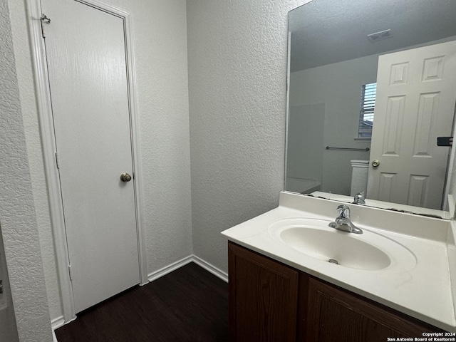 bathroom with vanity, hardwood / wood-style flooring, and toilet