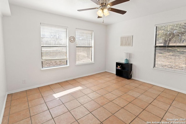 empty room with ceiling fan, a healthy amount of sunlight, and light tile patterned floors