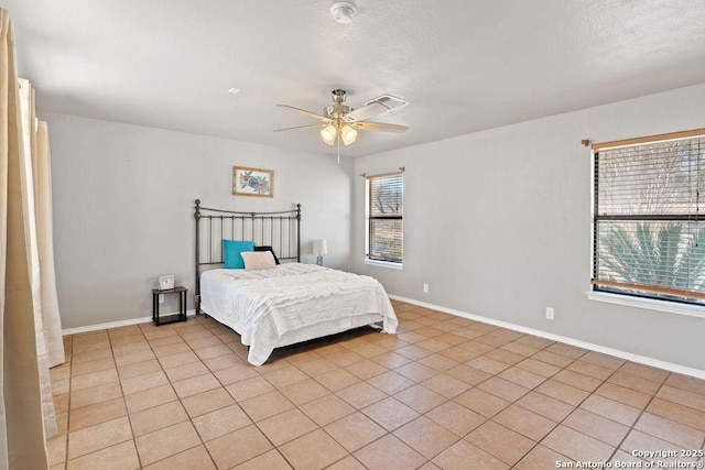 tiled bedroom featuring ceiling fan and a textured ceiling