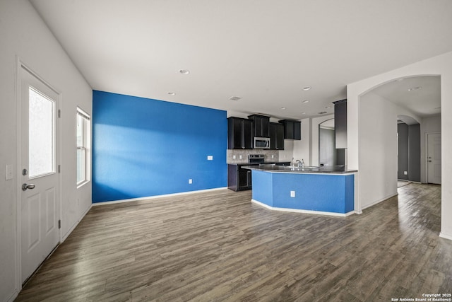 kitchen with decorative backsplash, dark hardwood / wood-style floors, a kitchen island, and sink