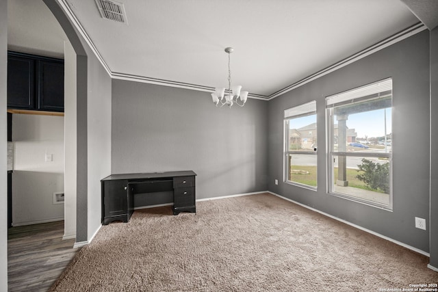 carpeted empty room with crown molding and a notable chandelier