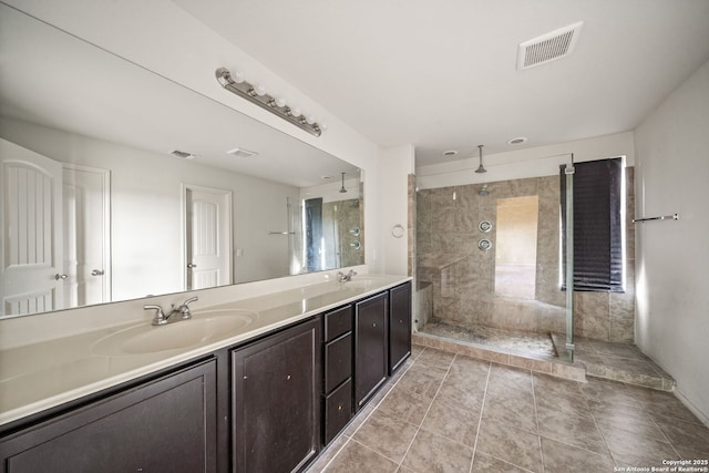 bathroom with a tile shower, tile patterned floors, and vanity