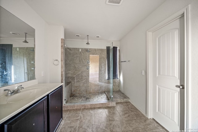 bathroom featuring tile patterned flooring, vanity, and a shower with shower door