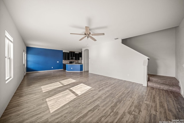 unfurnished living room featuring ceiling fan and wood-type flooring