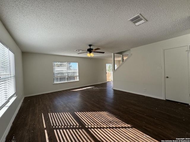 spare room featuring a textured ceiling, ceiling fan, and dark wood-type flooring