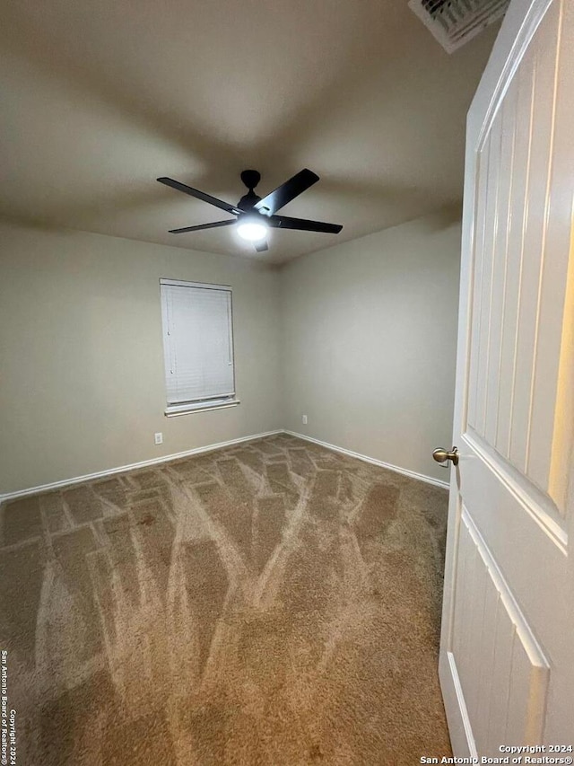 unfurnished room featuring ceiling fan and carpet