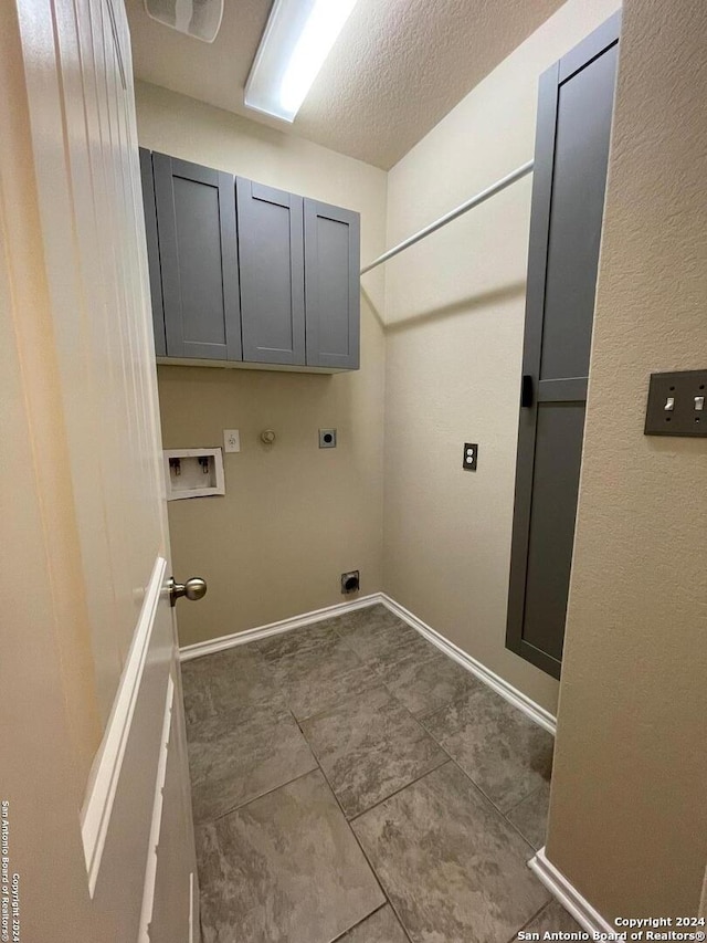 clothes washing area featuring cabinets, washer hookup, a textured ceiling, electric dryer hookup, and hookup for a gas dryer