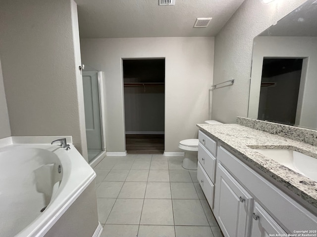 bathroom with vanity, a bathing tub, tile patterned flooring, toilet, and a textured ceiling