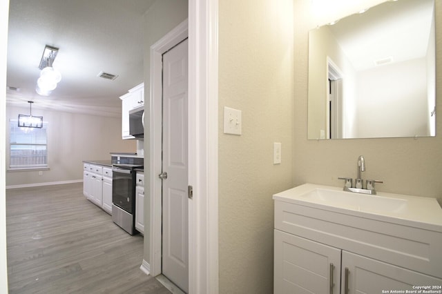 bathroom with sink, an inviting chandelier, and hardwood / wood-style flooring