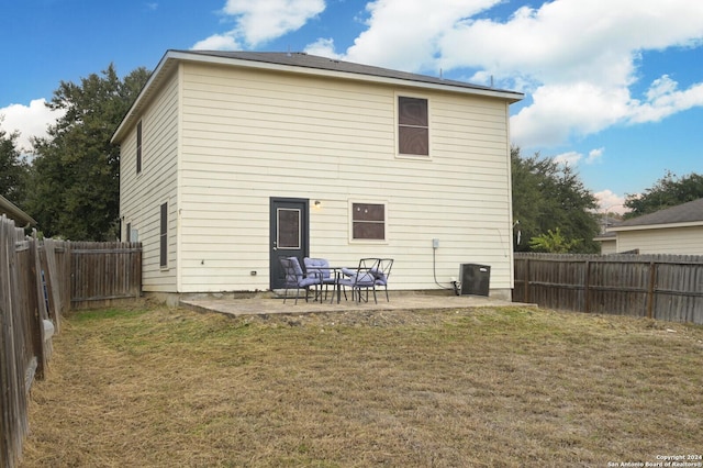 back of house featuring a lawn and a patio