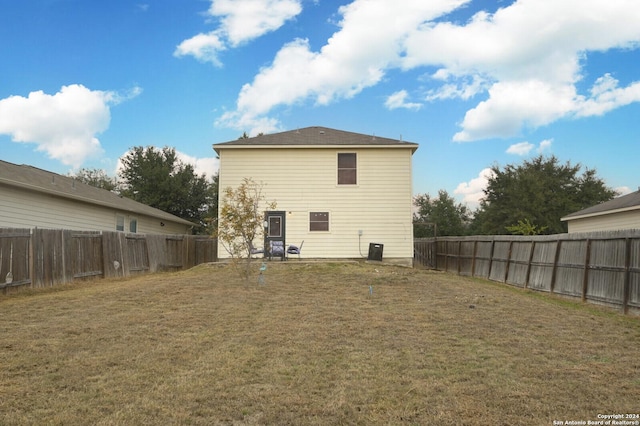 rear view of property featuring a lawn