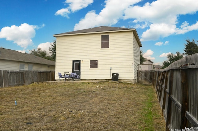 rear view of property featuring a lawn and a patio