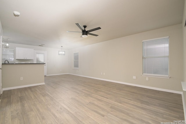 unfurnished living room featuring ceiling fan and light hardwood / wood-style flooring