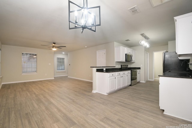 kitchen featuring white cabinetry, sink, pendant lighting, ceiling fan with notable chandelier, and appliances with stainless steel finishes