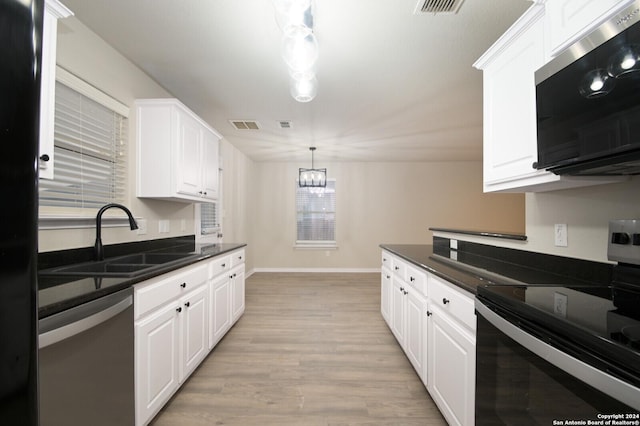 kitchen with appliances with stainless steel finishes, decorative light fixtures, white cabinetry, and sink