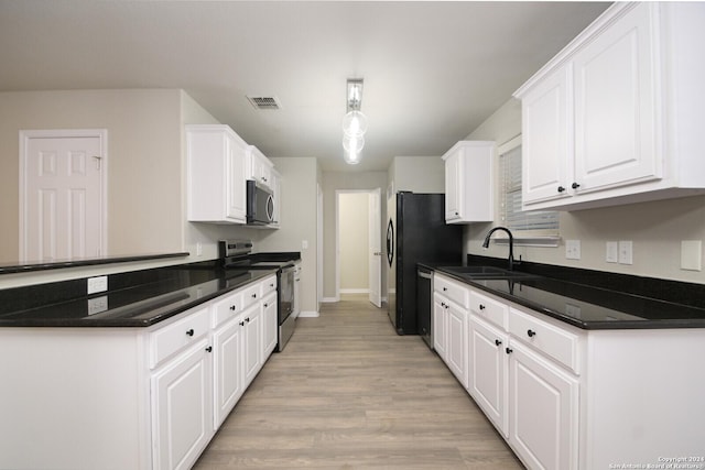 kitchen with appliances with stainless steel finishes, sink, decorative light fixtures, light hardwood / wood-style floors, and white cabinetry