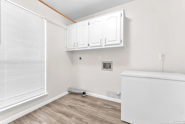 washroom featuring cabinets, hookup for a gas dryer, hookup for a washing machine, light hardwood / wood-style flooring, and hookup for an electric dryer