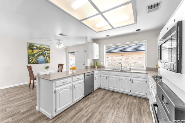 kitchen with dishwasher, white cabinets, sink, ceiling fan, and kitchen peninsula