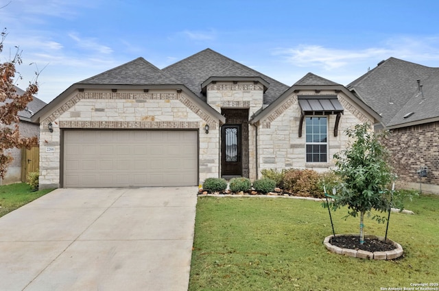 french country home featuring a garage and a front lawn